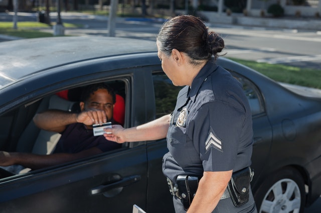 Person handing driver's license to police officer