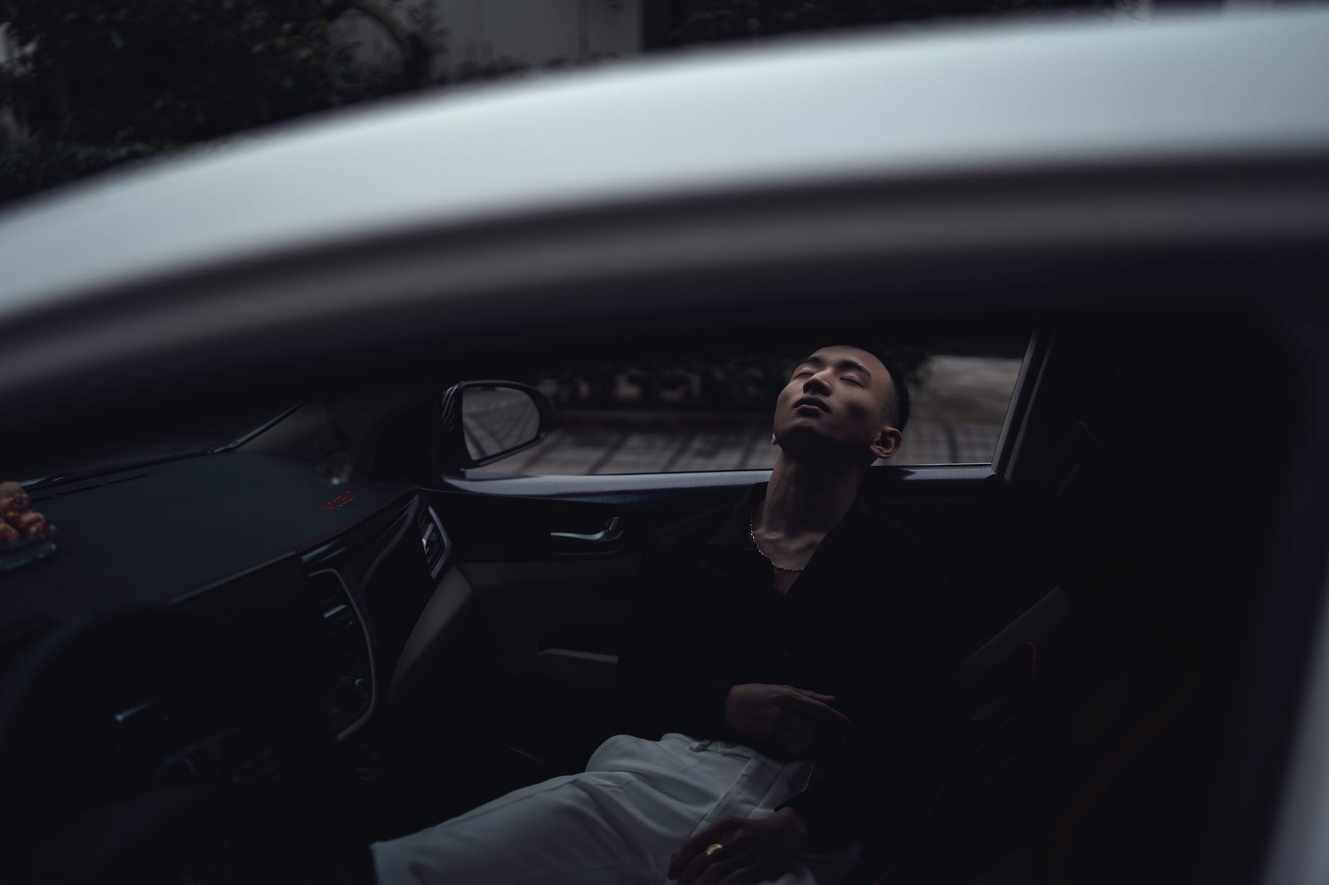 young ethnic man sleeping in car